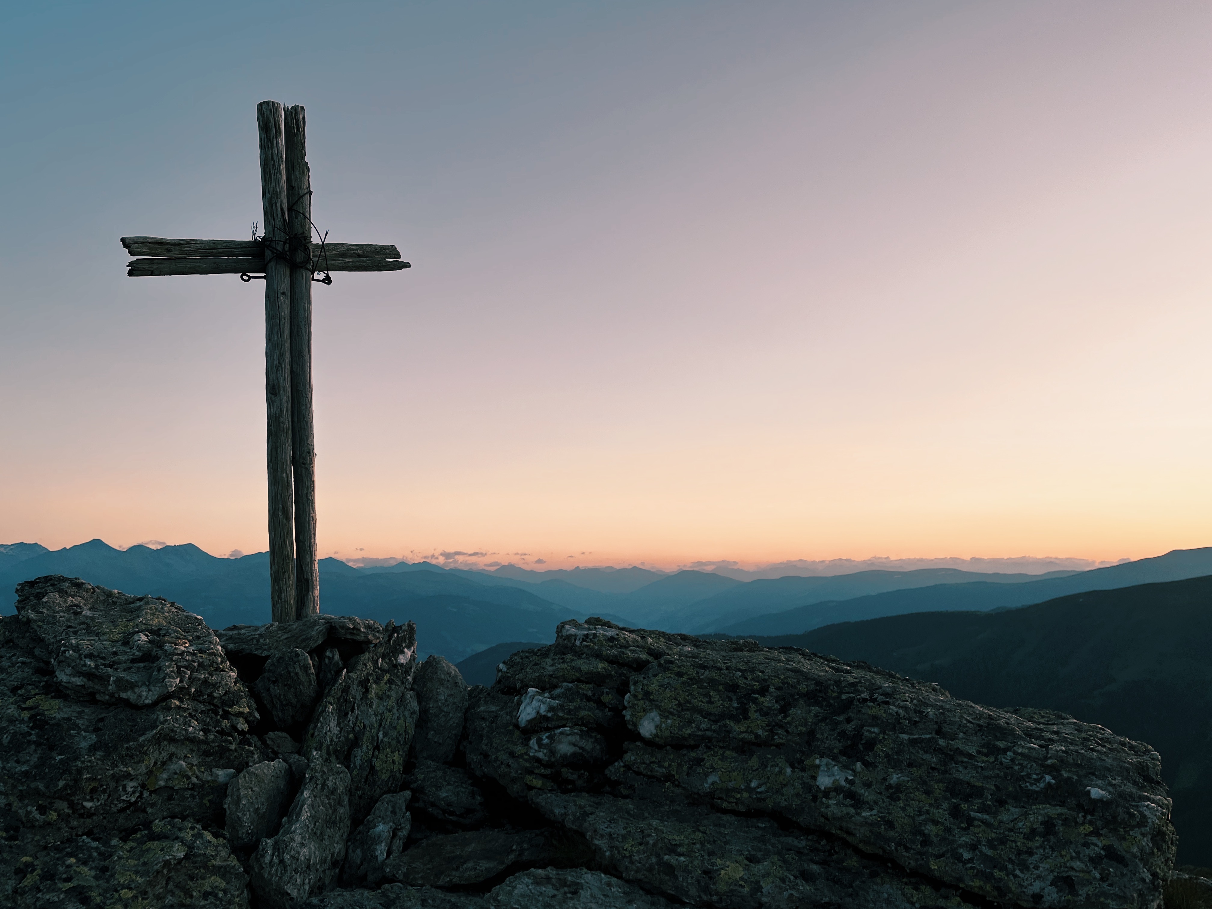 A summit cross at sunrise on the Alpe Adria Trail, the best thru-hiking trail for beginners