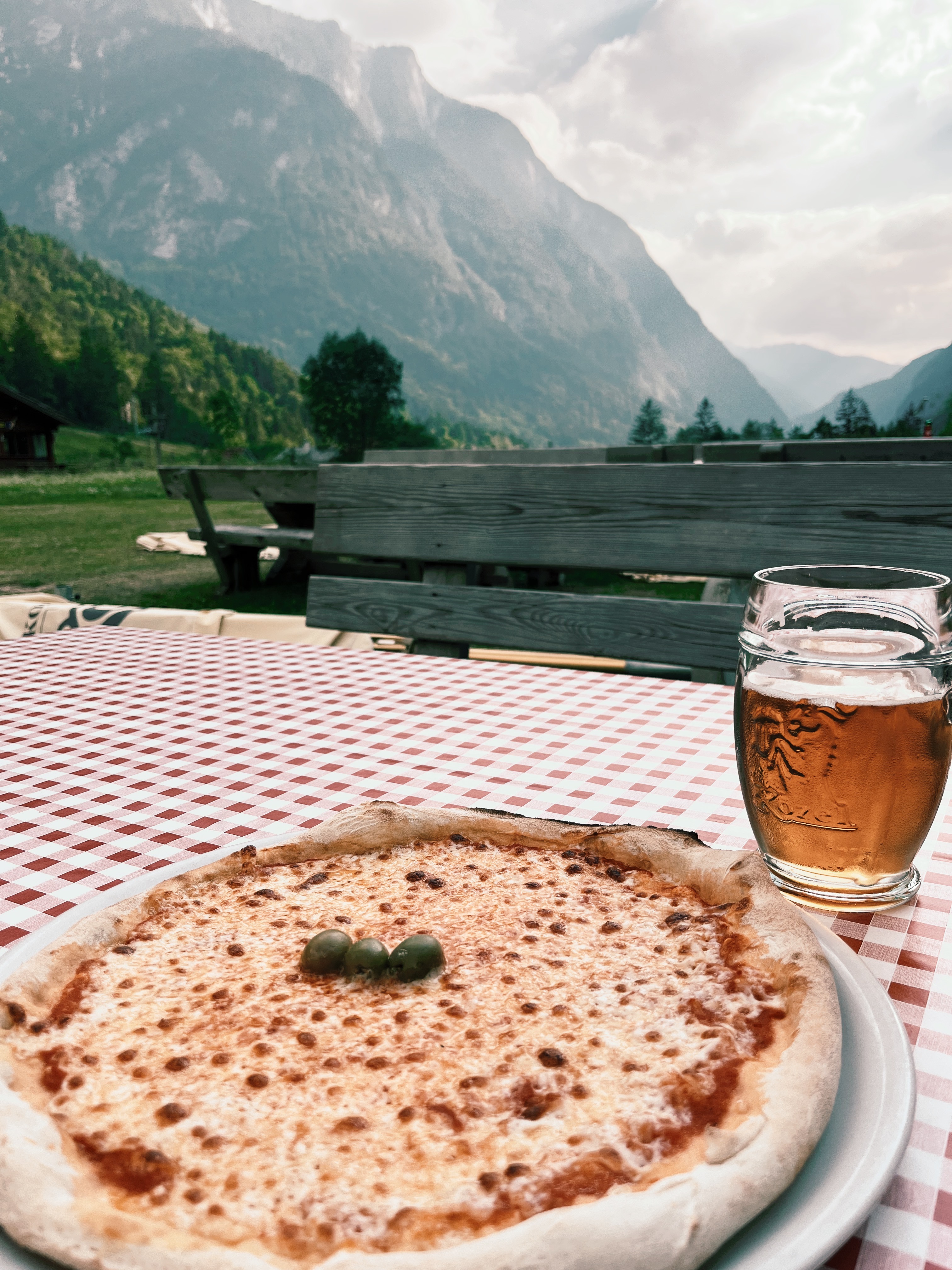 Pizza and Beer with view of the mountains in Trenta, Slovenia while hiking the Alpe Adria Trail