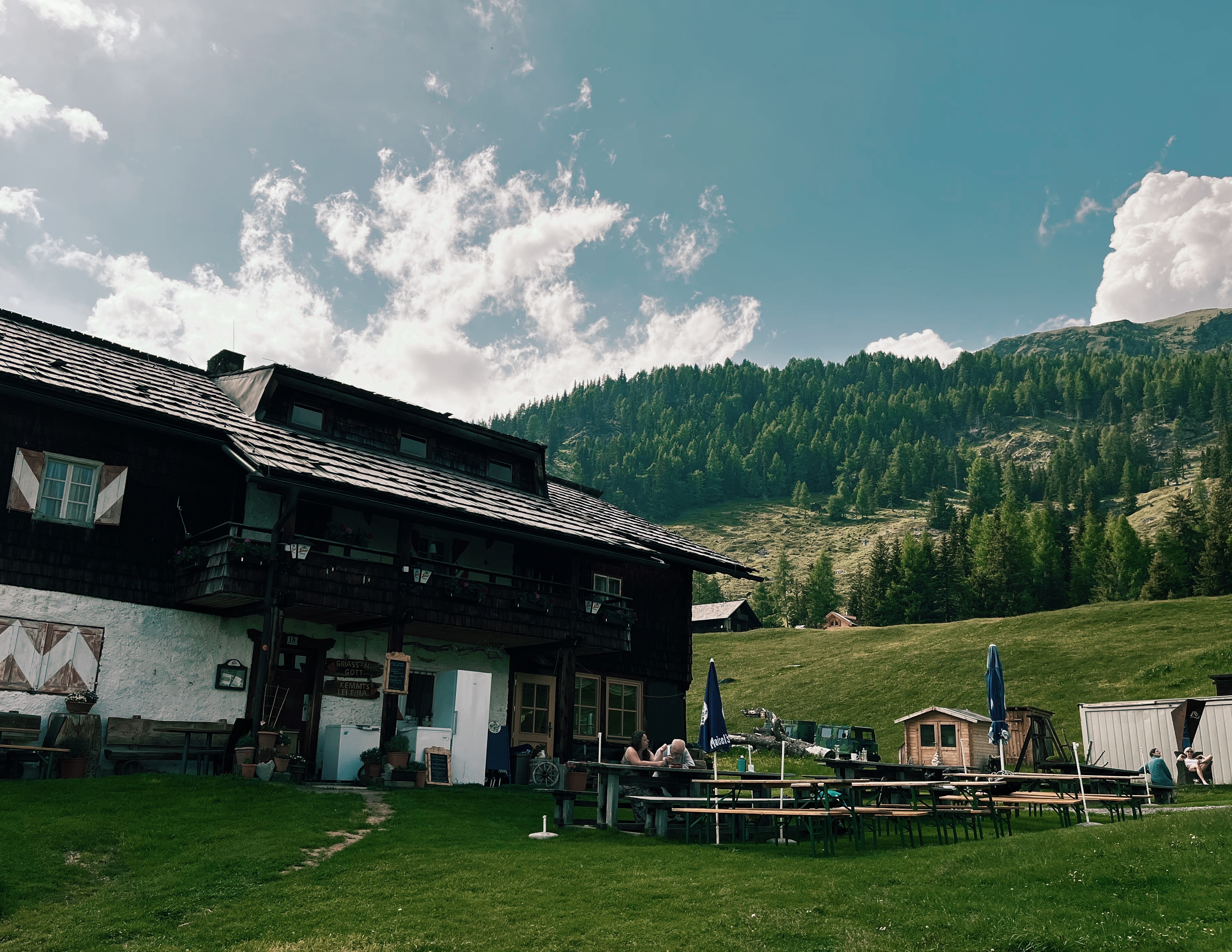 Alpengasthaus Marterle in front ouf mountain scenery while hiking the Alpe Adria Trail