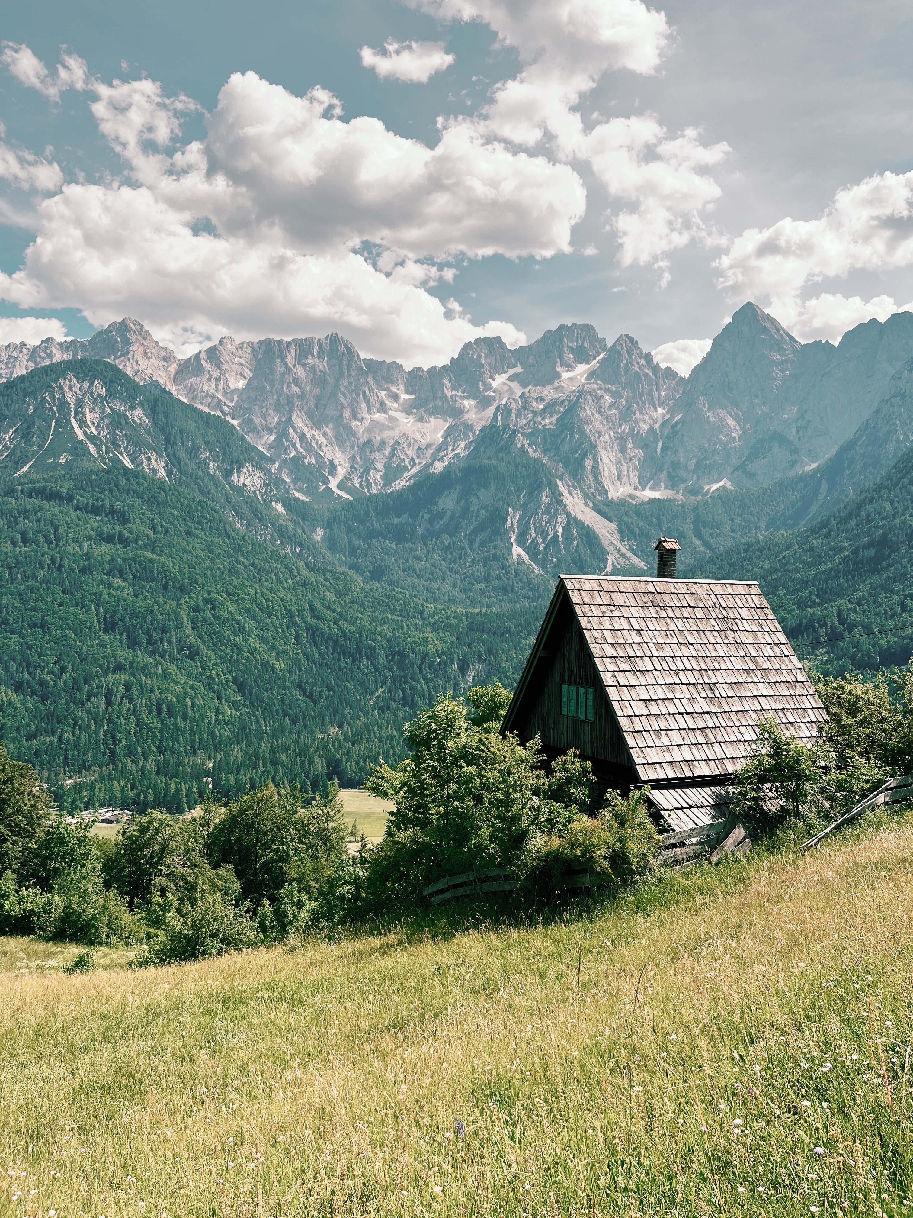 Mountain hut in front of Julian Alps while hiking the Alpe Adria Trail