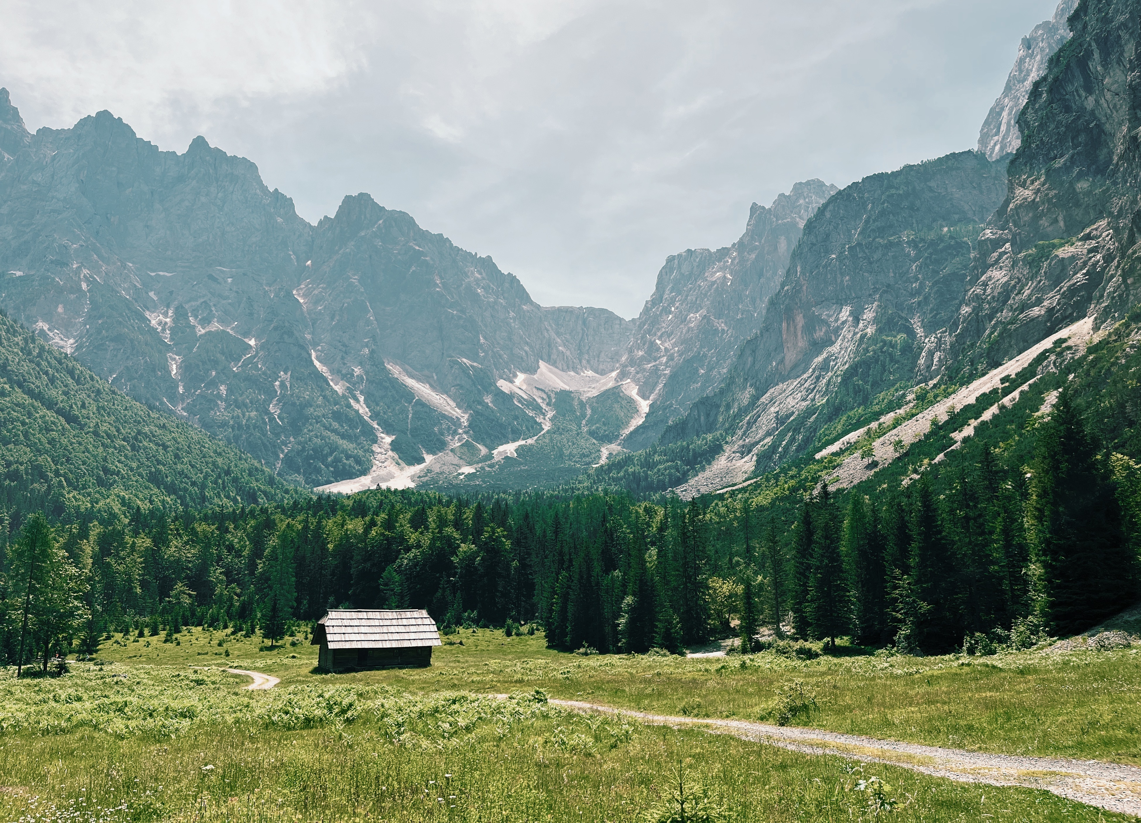 Mountain hut in front of Julian Alps while hiking the Alpe Adria Trail in Slovenia