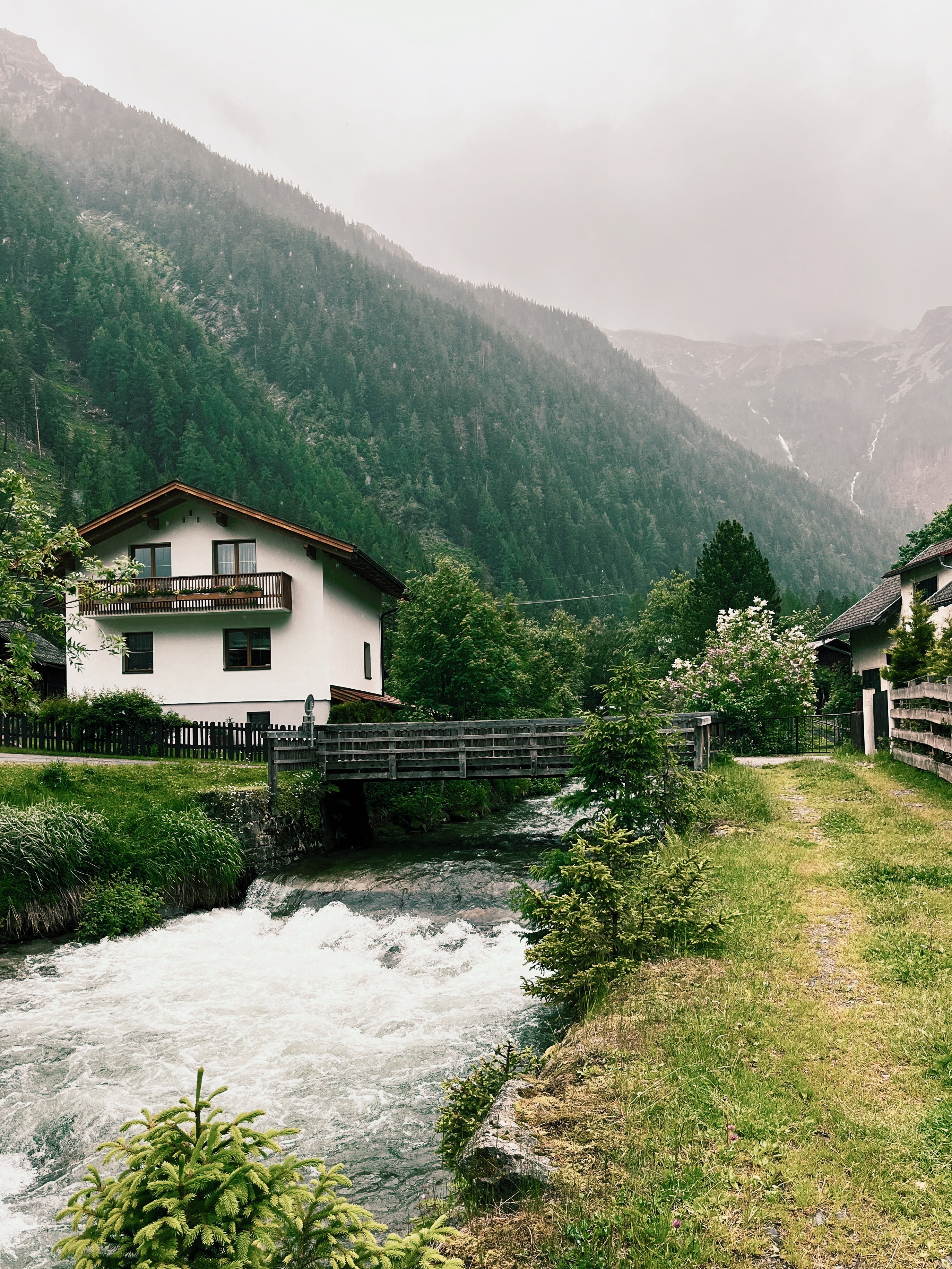 Traditional Austrian house next to river  on the Alpe Adria Trail, a long-distance hiking trail in Europe